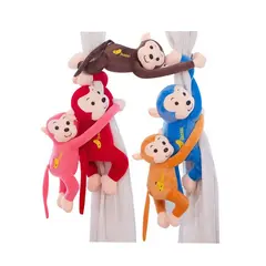 Maimuță de pluș cu brațe lungi agățată pe perdea